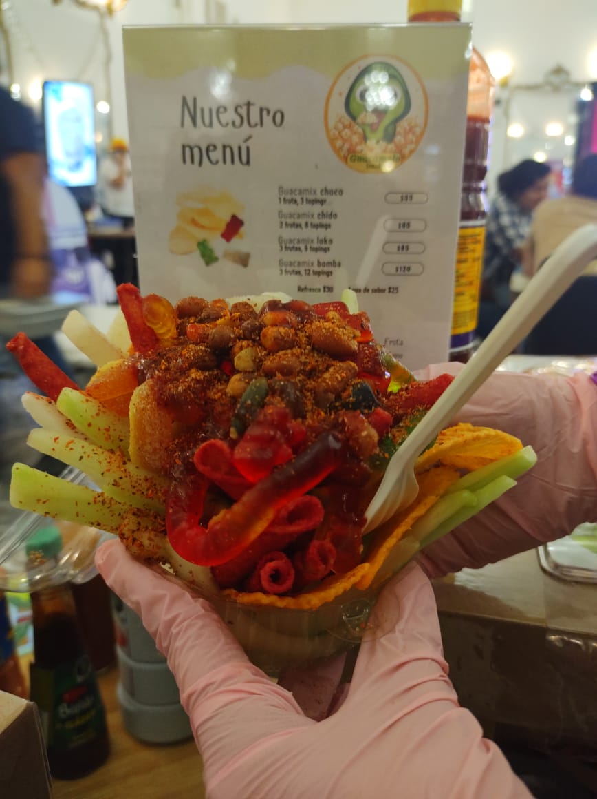 Guacamix colorido siendo presentado con manos enguantadas